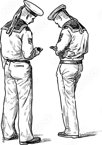 Two sailors stand with their mobile phones photo