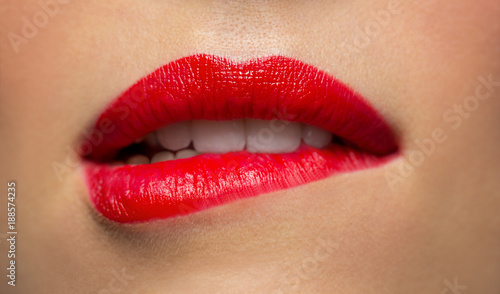 Foto close up of woman with red lipstick biting lip