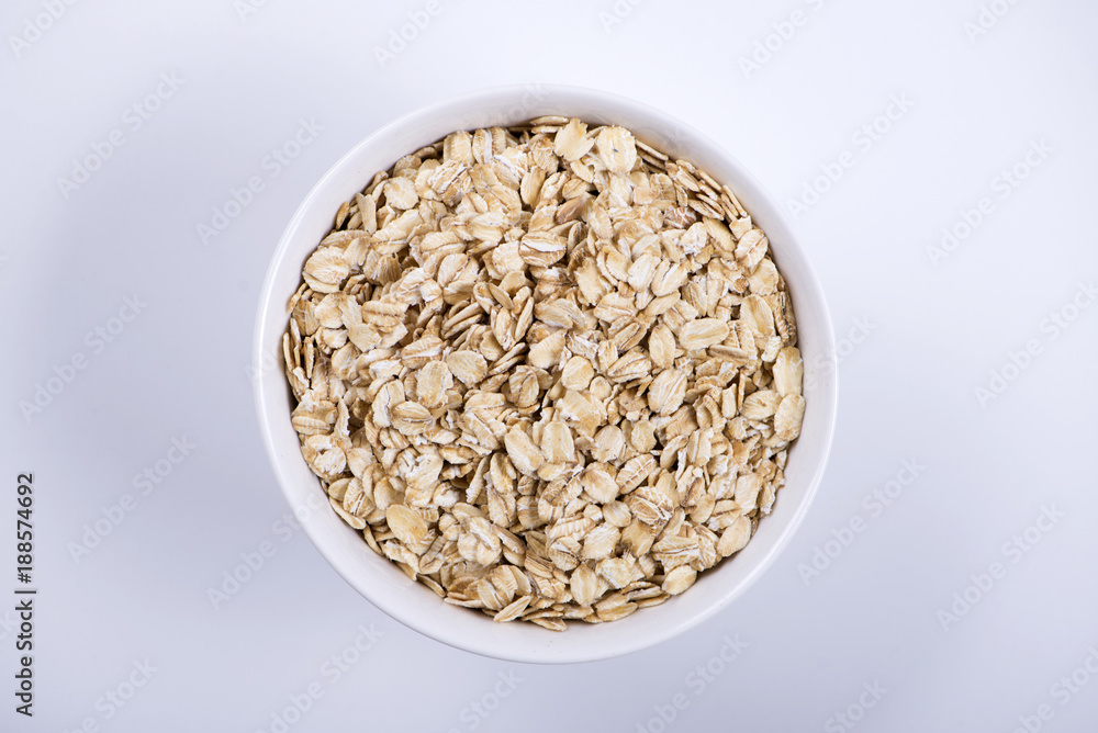 Top view of white bowl with oats on white background. Isolated. Top view of white bowl with oats on white background. Isolated.