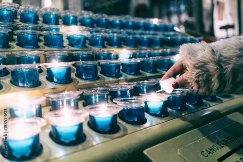 Woman's hand lighting candles in church. New York. photo