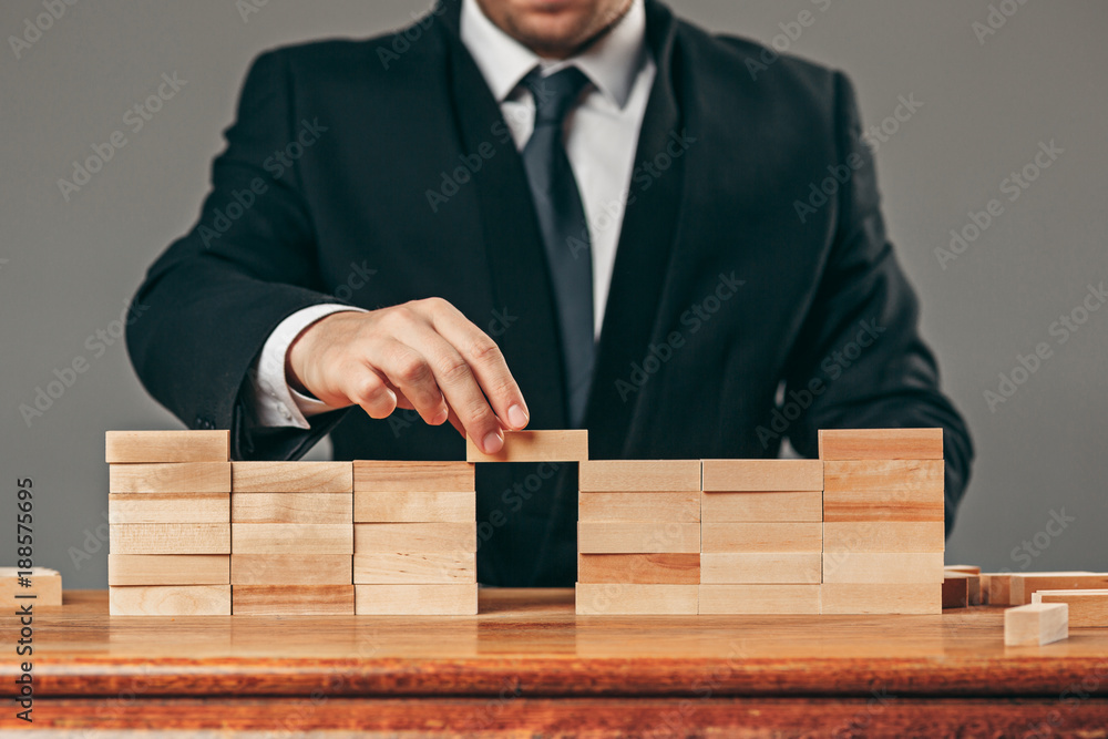Man and wooden cubes on table. Management concept Man and wooden cubes on table. Management concept