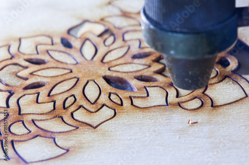 The laser cuts out a tree in the form of a mandala 