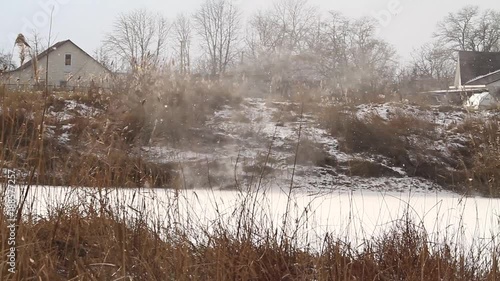 snowstorm over a lake on the outskirts of the village photo