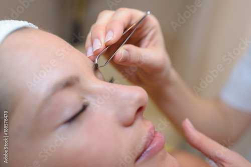 Closeup of woman having eyebrows plucked