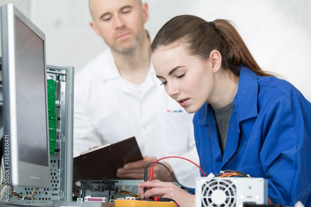 tutor and student fixing computer in class tutor and student fixing computer in class