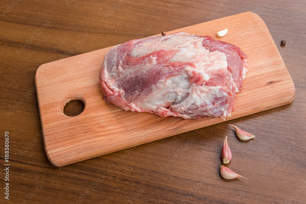 Raw pork meat on cutting board on a table