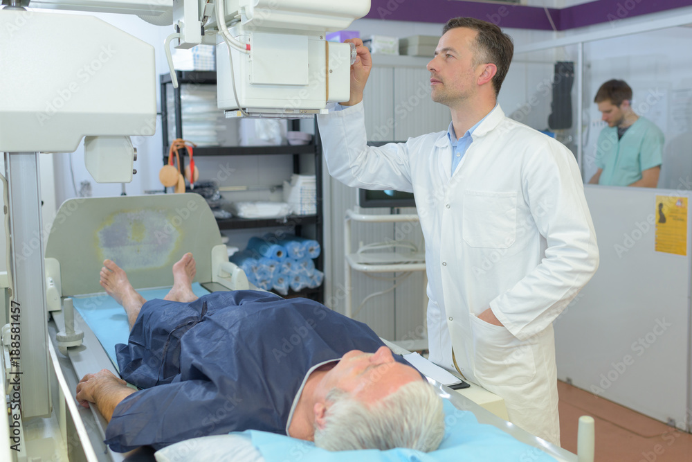 Fototapeta premium female doctor with male patient undergoing scanner