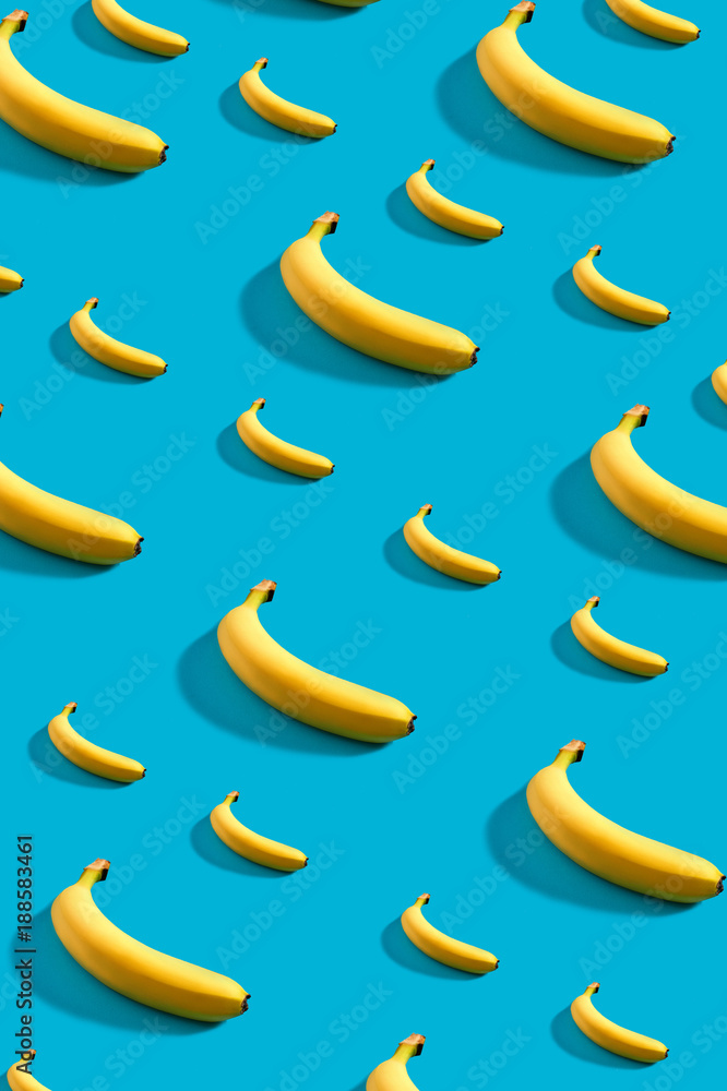 Colorful pattern of bananas on sky blue background.