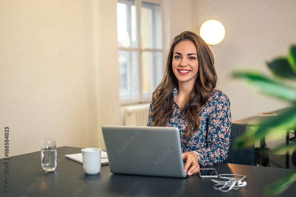 Young attractive businesswoman in modern office working on laptop. Young attractive businesswoman in modern office working on laptop.