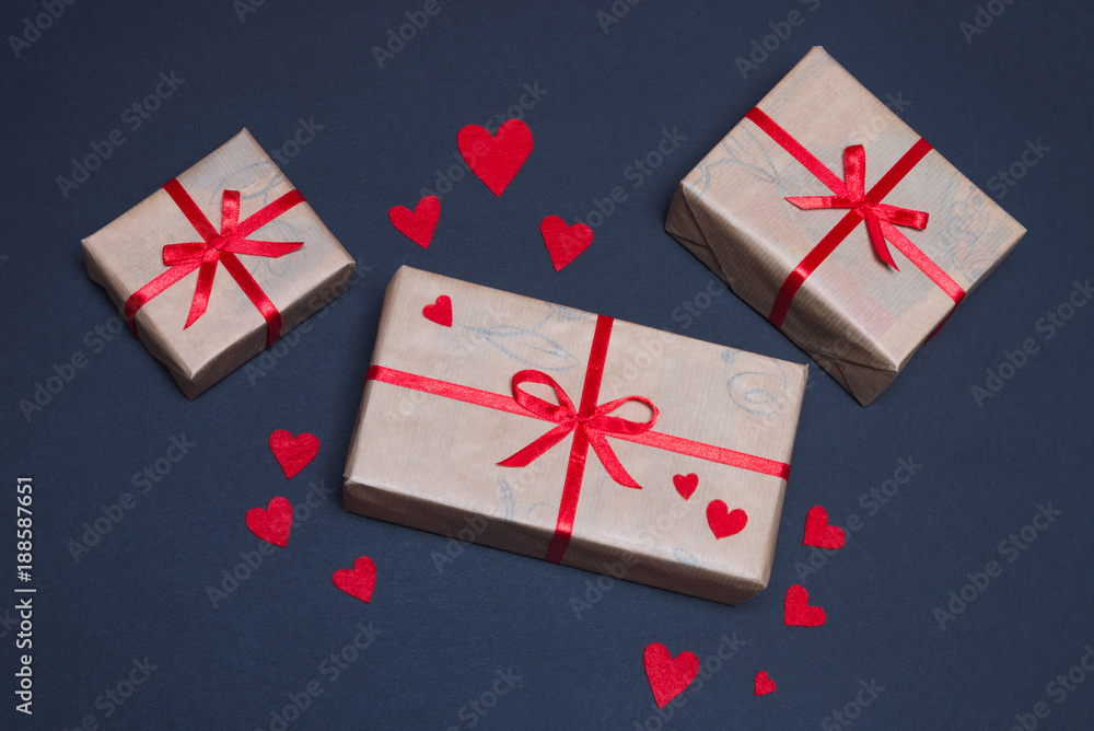Gift boxes decorated with red ribbons with bows lie on a black background Gift boxes decorated with red ribbons with bows lie on a black background