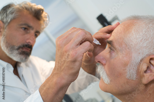 nurse putting eye drops to the patients eyes