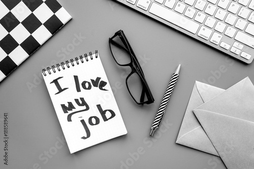 Find dream job. Handwritten motto I love my job in notebook on office desk on grey background top view photo