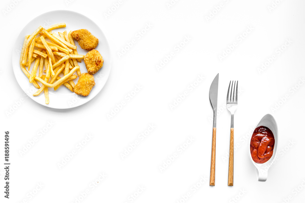 Fast food reastaurant. Chiken nuggets and french fries on plate on white background top view space for text Fast food reastaurant. Chiken nuggets and french fries on plate on white background top view space for text