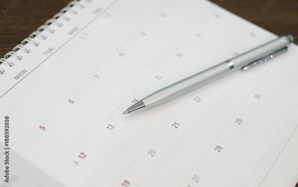 close up business pen lay on calendar schedule page paper for make important appointment concept. close up business pen lay on calendar schedule page paper for make important appointment concept.