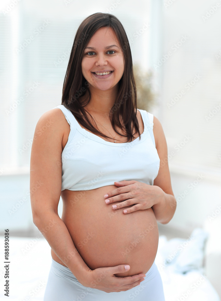 portrait of young pregnant woman on a light background. portrait of young pregnant woman on a light background.