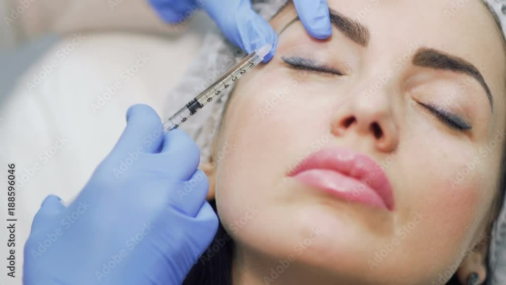 Woman lifts her eyelid and makes cosmetological procedure with botox Woman lifts her eyelid and makes cosmetological procedure with botox