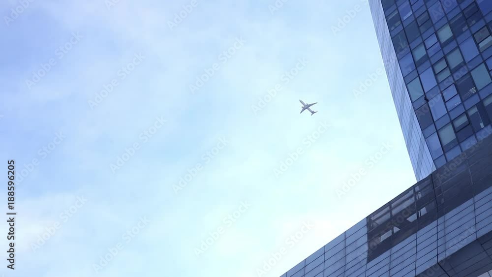Airplane flying above glass office buildings and futuristic design Airplane flying above glass office buildings and futuristic design
