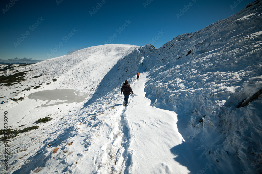 hikers in the snowy mountains. rises to the top of the mountain