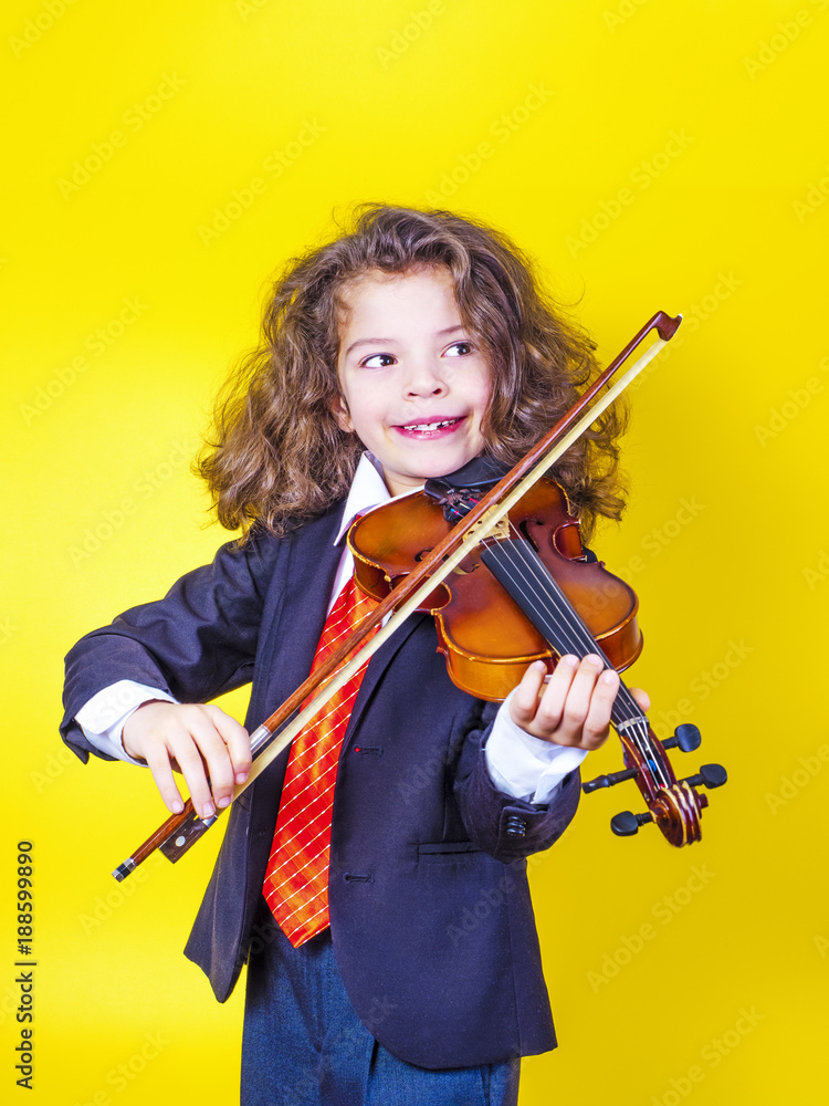 Dark-haired preschool boy with violin isolated on yellow, musical concept