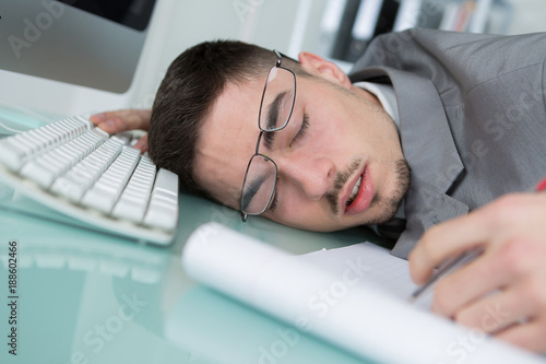young man sleeping at his desk