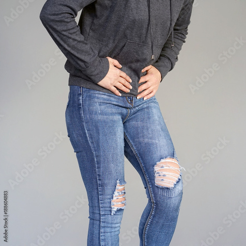Close-up view of a young woman having painful stomachache on gray background. Chronic gastritis. Body And Health Care Concept.