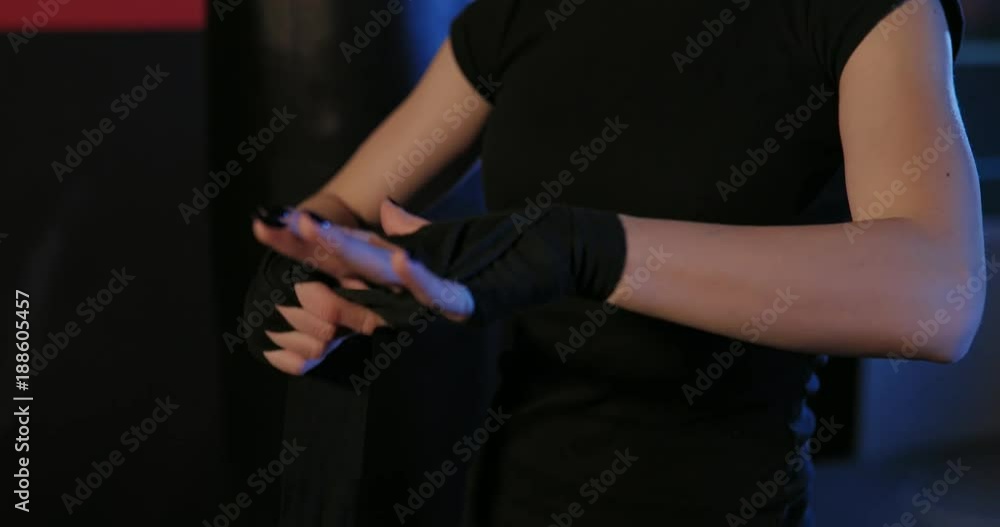 Girl shakes boxing bandages. Close up of woman putting on punching wraps. Close up. Boxer shakes special bandages on his hands. Girl shakes boxing bandages. Close up of woman putting on punching wraps. Close up. Boxer shakes special bandages on his hands.