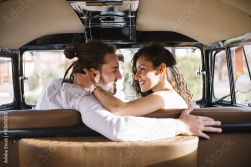 Happy young couple sitting in van © karrastock