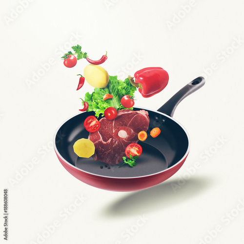 Flying organic food and fresh meat on frying pan. Food illustration different vegetables and fresh meat on isolated white background