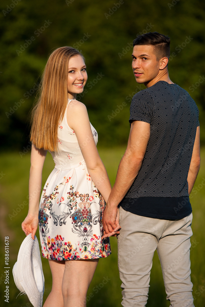 Obraz premium Active young couple on a wlak in the park on hot summer afternoon