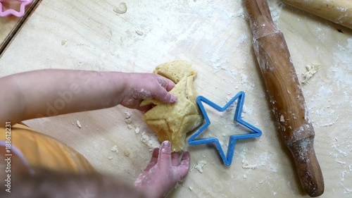 Small hands kneading dough. Little child preparing dough for backing photo