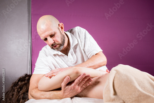 Masseur hands doing spine and back massage, neck and hand. Relaxed patient enjoys. Man hands massaging female. Spa centre concept. close-up