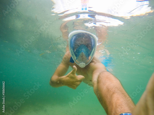 Underwater selfie with a man snorkeling in the blue sea