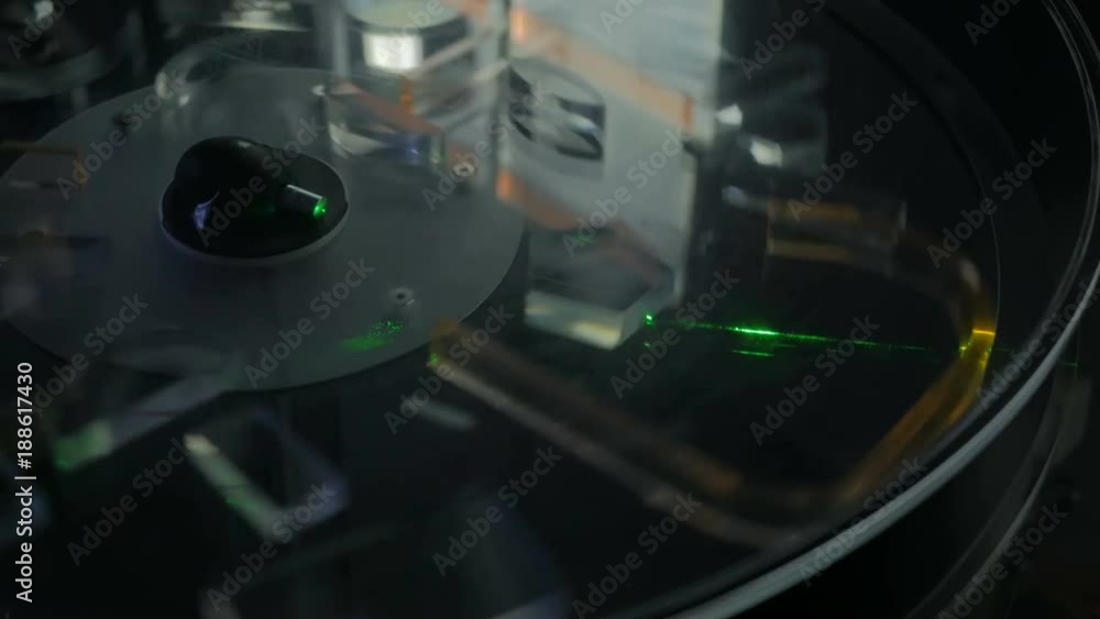 Ray of green laser lights through different transparent figures in spinning platform - effect of refraction. Optical, experiment and technology concept Ray of green laser lights through different transparent figures in spinning platform - effect of refraction. Optical, experiment and technology concept