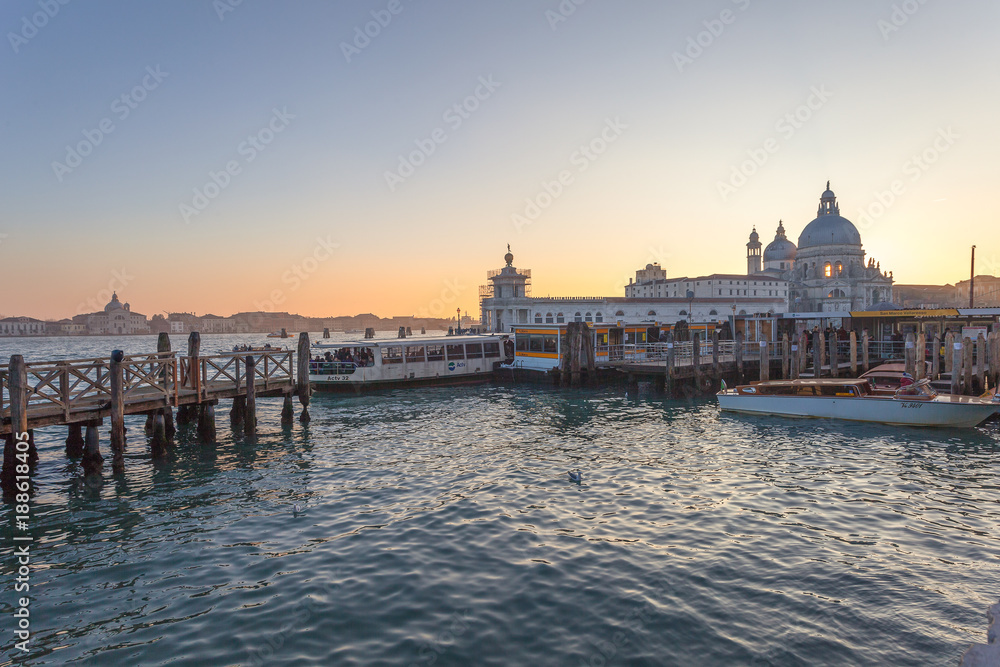 VENICE, ITALY - JANUARY 02 2018: vaporetto terminal  at sunset in front of Basilica della Salute. The vaporetto is the public means par excellence of the city