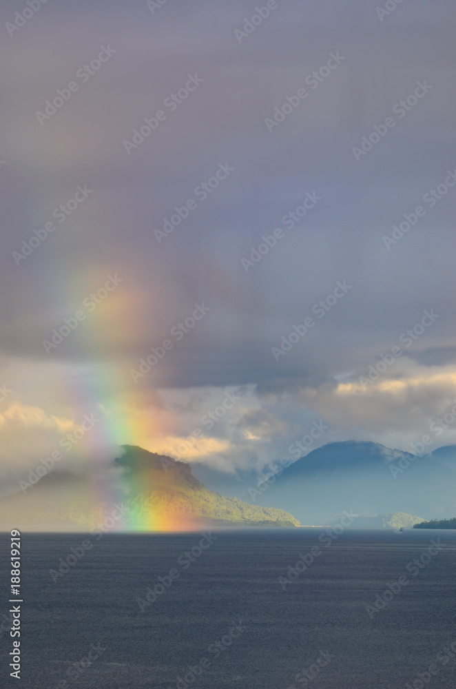 rainbow over lake and mountains