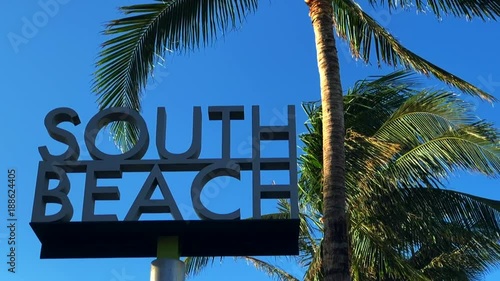 South Beach sign against palm trees in bright blue sky in Miami, Florida 