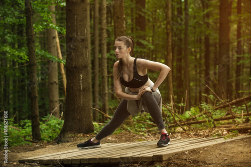 The girl is engaged in fitness in the forest. Sport in the forest