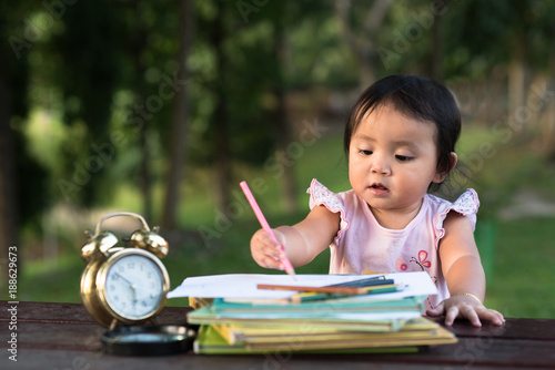 asian little baby toddler drawing at park with copy space. early ecucation concept. photo