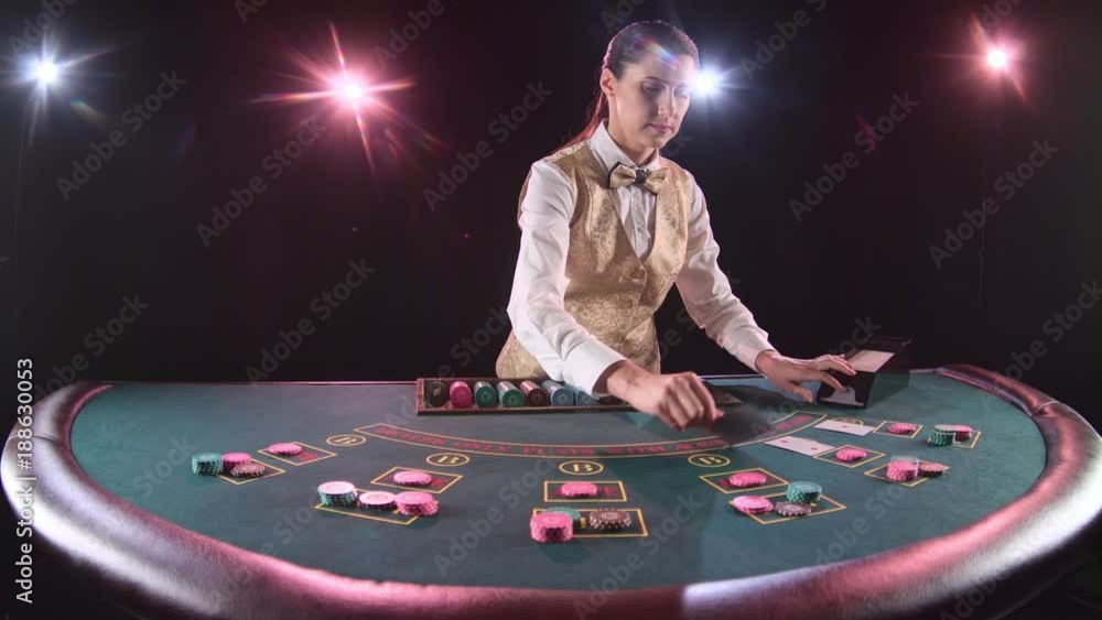 Casino dealer handling playing cards at a poker table. Black background. Slow motion Casino dealer handling playing cards at a poker table. Black background. Slow motion