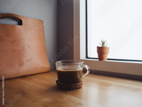 Hot coffee cup on the table in low light condition by the window. Concept of relax and concentrate.