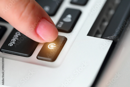 human hand press shutdown button on computer keyboard photo