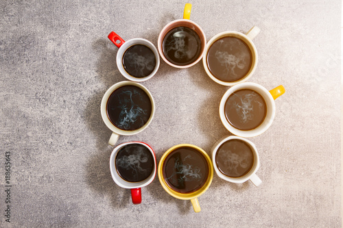 colorful cups of coffee on concrete background,top view