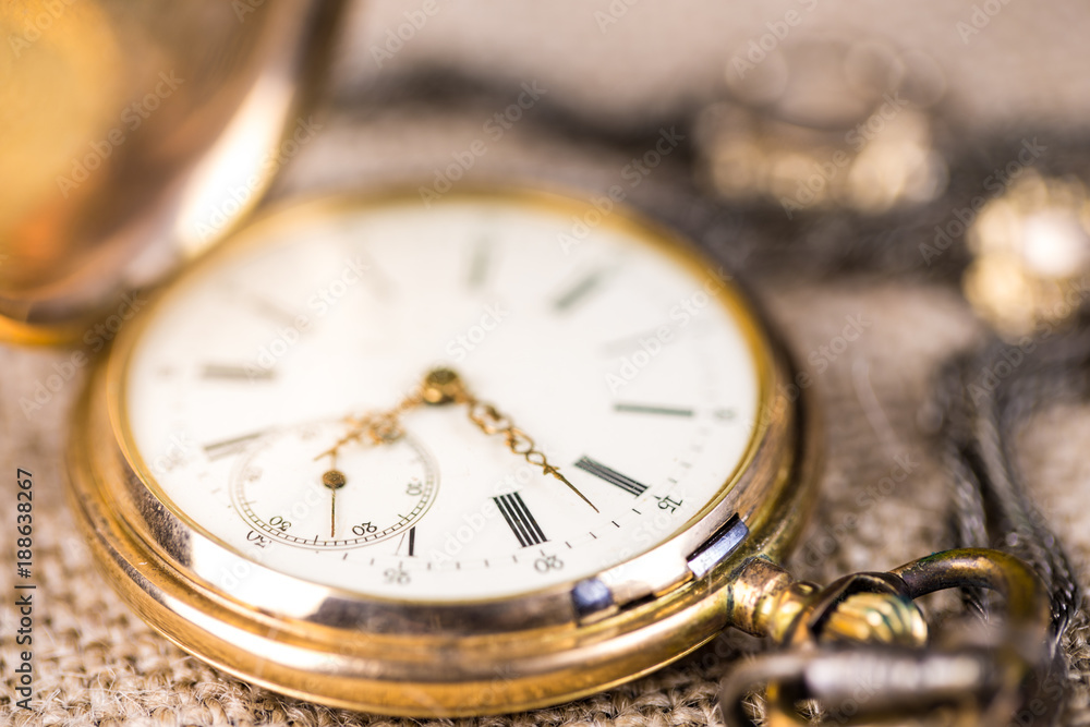 eine alte, goldene Taschenuhr liegt auf einem groben Tuch eine alte, goldene Taschenuhr liegt auf einem groben Tuch