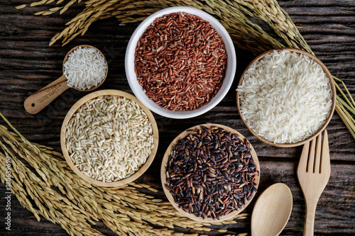 Closeup Brown rice, Black Jasmine rice, Red jasmine rice and Riceberry in bowl on wooden desk. photo