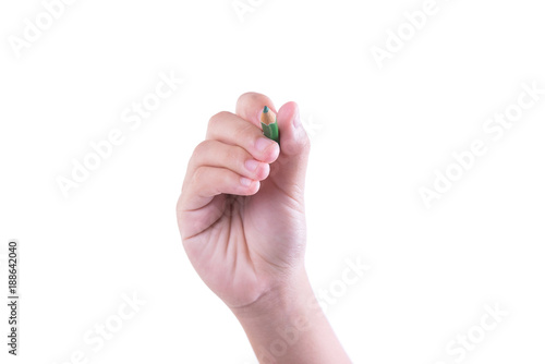 A woman holding a green pencil with her right hand and writing on a white background.