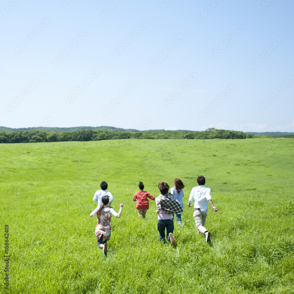 草原を走る若者たちの後姿