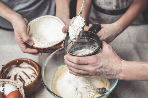 Mothers and children's hands cook dough for home-made cookies. We cook in kitchen together with children. Happy family