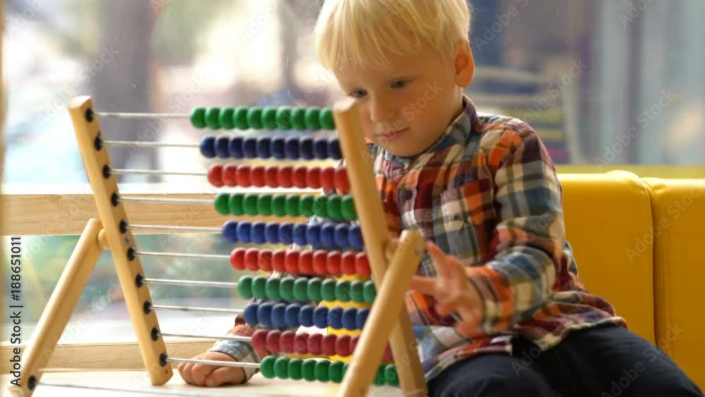 boy in kindergarten playing with abacus