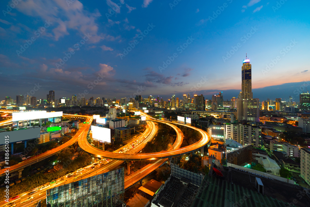 Bangkok City with Curved Express Way and Skyscraper. Top View of City Elevated Highway with Car Traffic Light Trial at Twilight Time.