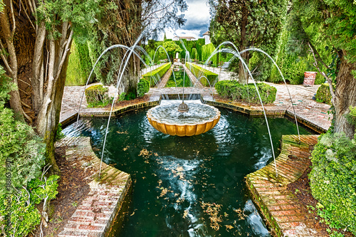 Close up of fountain in the famous avenue of cypress trees, Generalife gardens near Alhambra complex, Granada, Andalucia, Spain, one of the most beautiful in the world and is a Unesco heritage.